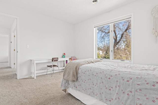 carpeted bedroom featuring visible vents and baseboards