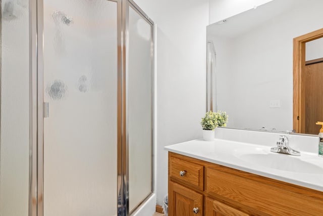 bathroom with a shower stall and vanity