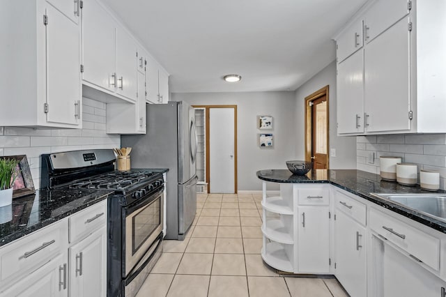 kitchen featuring open shelves, light tile patterned flooring, stainless steel gas range oven, white cabinetry, and backsplash