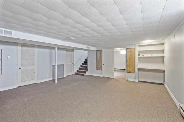 finished below grade area featuring stairway, baseboards, light carpet, and visible vents