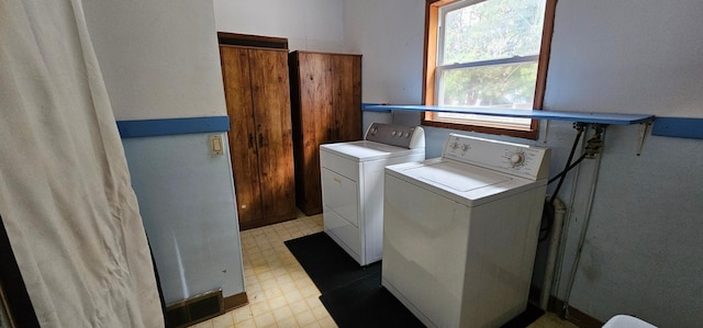 washroom with light floors, laundry area, and washer and dryer