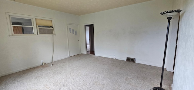 carpeted empty room featuring visible vents and baseboards