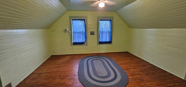 bonus room with a ceiling fan, wood walls, vaulted ceiling, and hardwood / wood-style floors