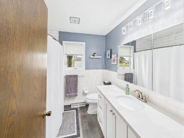 full bathroom featuring vanity, toilet, tile walls, wood finished floors, and visible vents