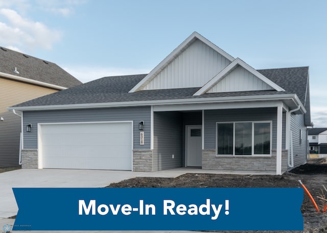view of front of property featuring concrete driveway, board and batten siding, an attached garage, and stone siding