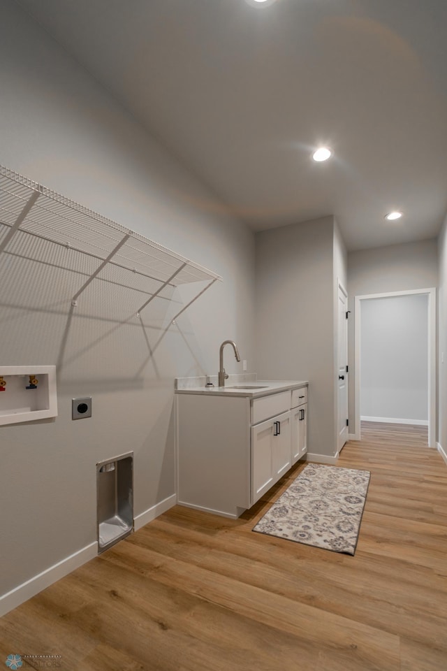 laundry area featuring a sink, washer hookup, hookup for an electric dryer, and light wood-style flooring