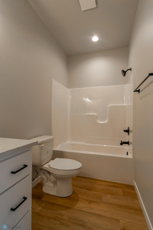 full bath with vanity,  shower combination, wood finished floors, and toilet