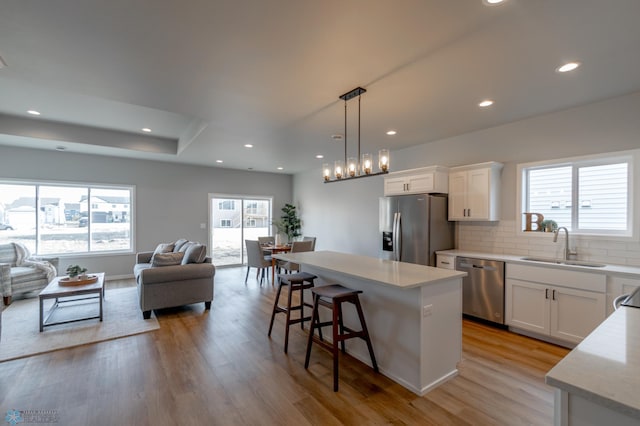kitchen featuring a sink, light wood-style floors, stainless steel appliances, and open floor plan