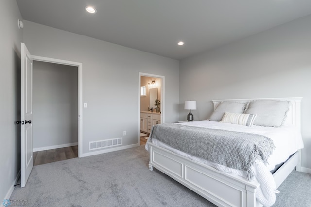 bedroom featuring carpet flooring, baseboards, visible vents, and connected bathroom