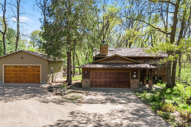 view of front of home featuring a detached garage and a chimney