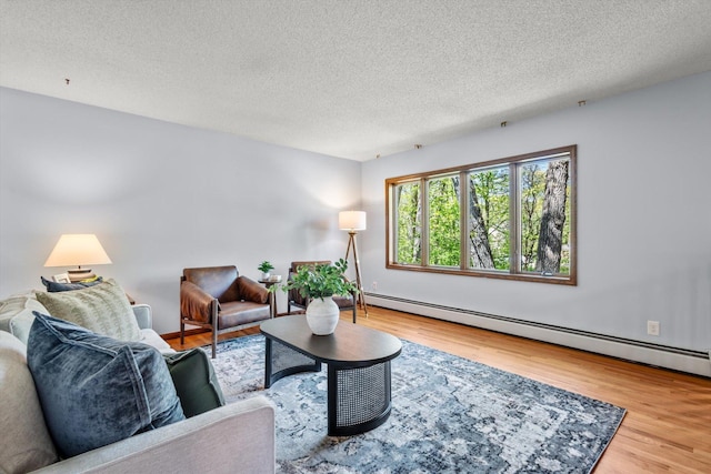living area with a baseboard radiator, wood finished floors, and a textured ceiling