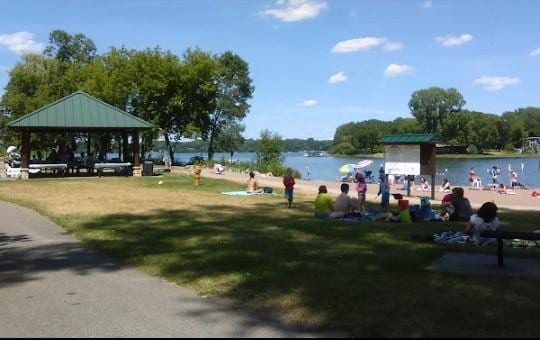 view of property's community featuring a gazebo, a water view, and a lawn