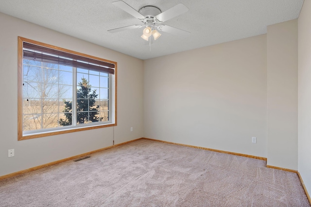 carpeted empty room featuring baseboards, a ceiling fan, and a textured ceiling