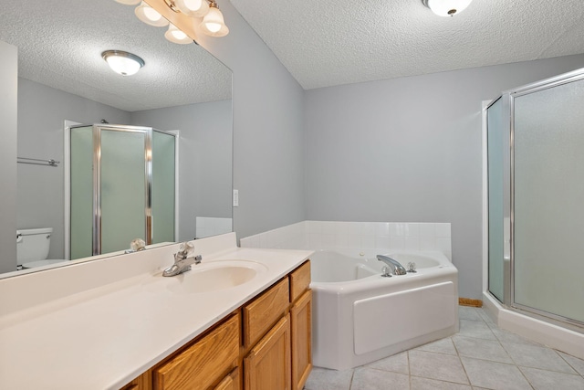 bathroom with a textured ceiling, a shower stall, a garden tub, vanity, and tile patterned floors