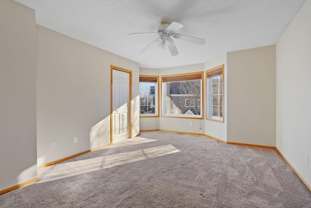spare room featuring carpet, a ceiling fan, a textured ceiling, and baseboards