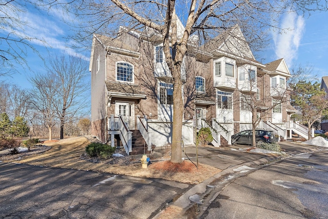view of property with driveway and brick siding