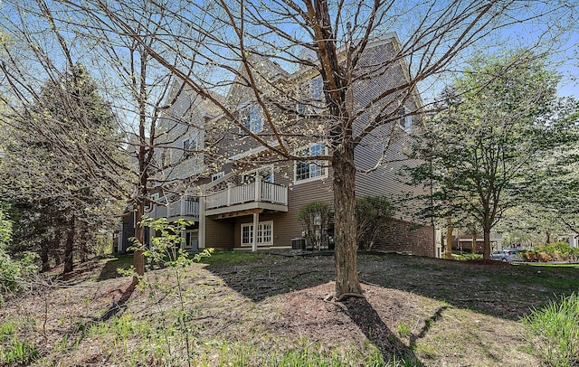 back of house with a wooden deck and central air condition unit