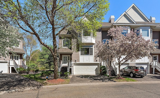 townhome / multi-family property featuring stairway, a garage, and a chimney