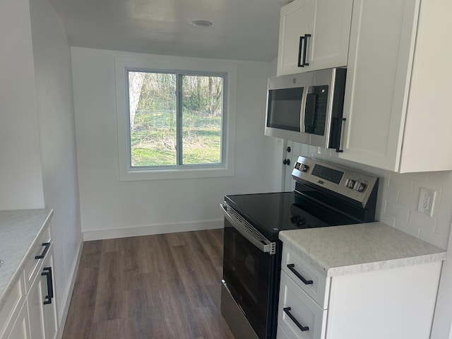 507 Peck St, Fergus Falls, MN 56537 - kitchen with stainless steel appliances, white cabinetry, light countertops, decorative backsplash, and dark wood-style floors