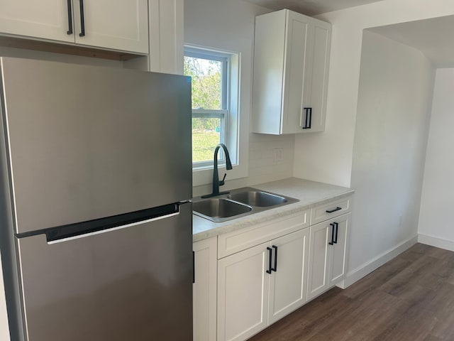 507 Peck St, Fergus Falls, MN 56537 - kitchen with a sink, freestanding refrigerator, white cabinets, light countertops, and dark wood-style floors