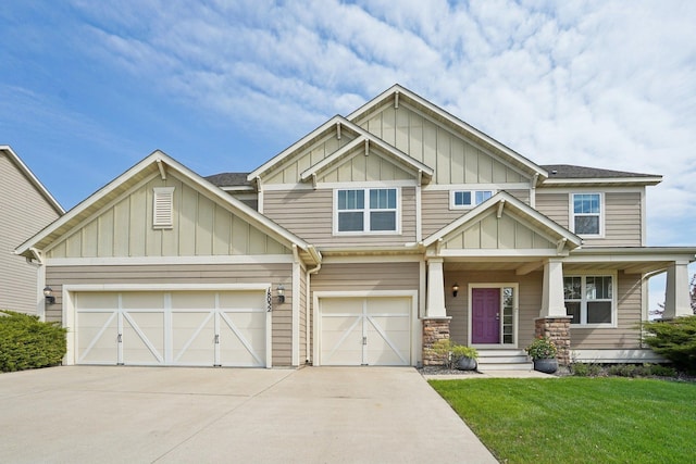 craftsman-style house featuring board and batten siding, concrete driveway, a front lawn, a garage, and covered porch