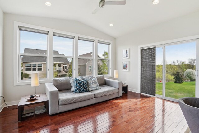 living area featuring vaulted ceiling, hardwood / wood-style floors, healthy amount of natural light, ceiling fan, and baseboards