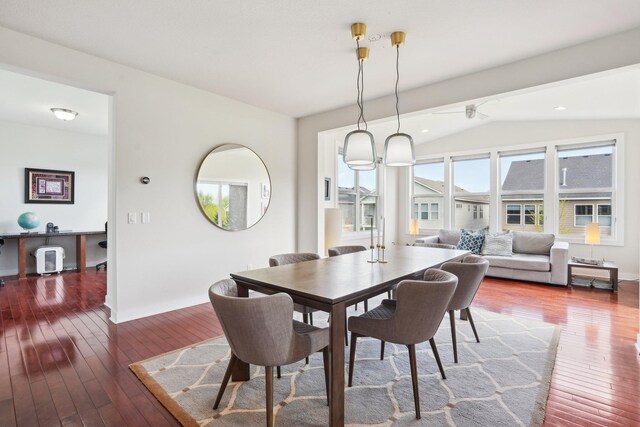 dining area with wood-type flooring, lofted ceiling, and baseboards