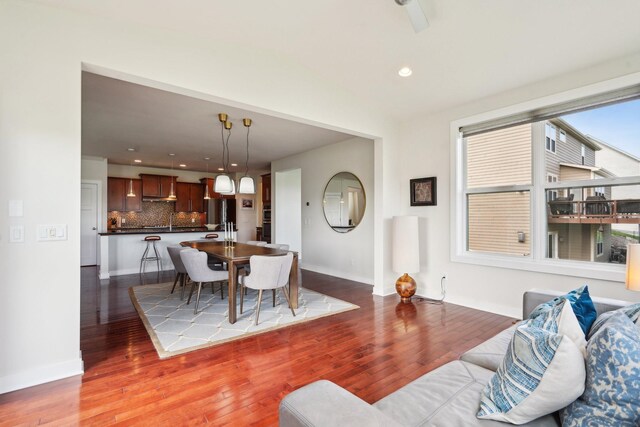 living room with wood finished floors, recessed lighting, baseboards, and lofted ceiling