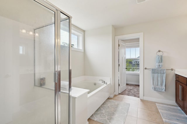 full bath with a stall shower, tile patterned flooring, a garden tub, and vanity