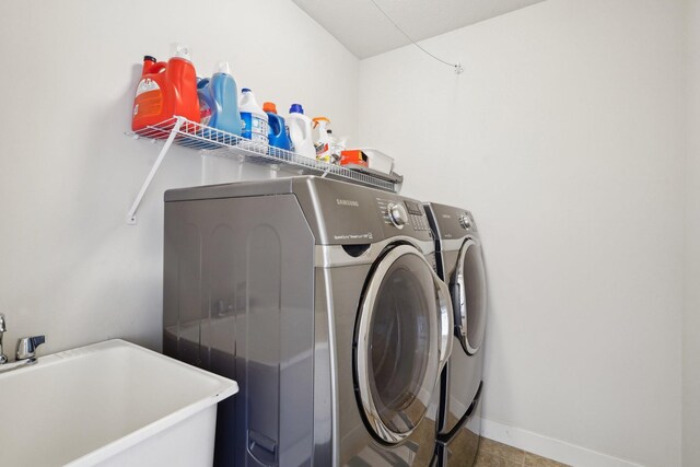 laundry area with washing machine and dryer and baseboards