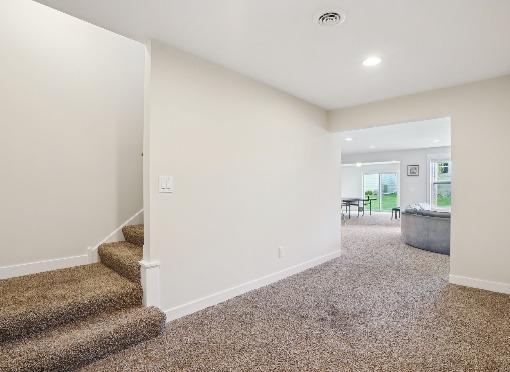 corridor featuring recessed lighting, baseboards, stairway, and carpet