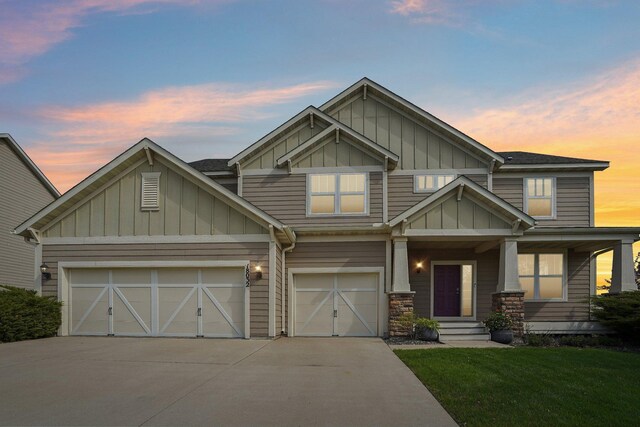 craftsman house with board and batten siding, driveway, a front lawn, a porch, and a garage