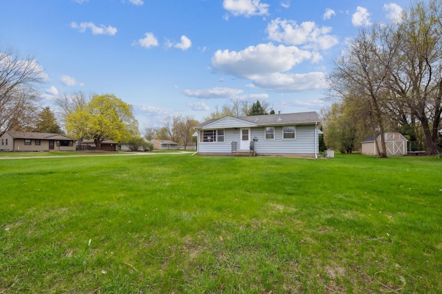 back of property featuring an outbuilding, a yard, and a storage shed
