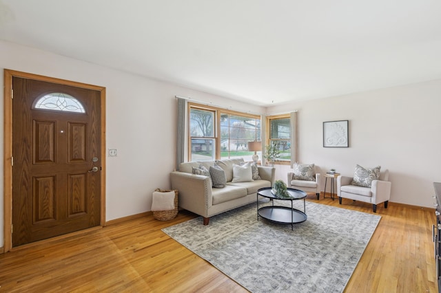 living area featuring light wood-style floors and baseboards