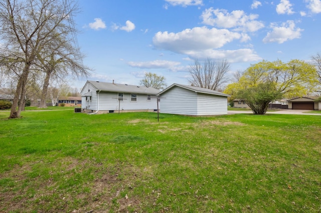 rear view of property featuring a garage and a yard