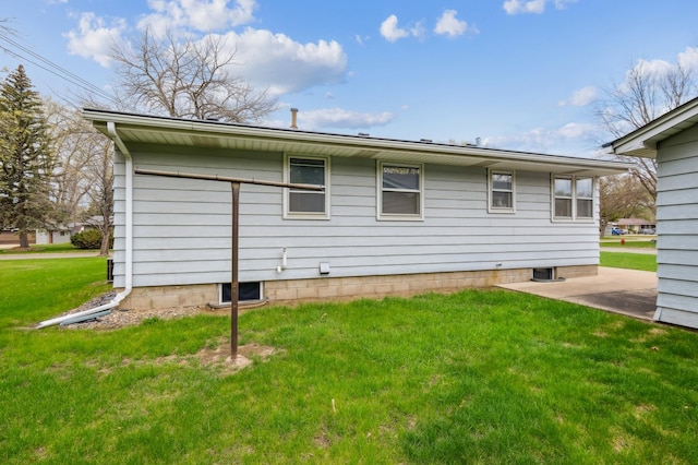 back of property with a yard and a patio area