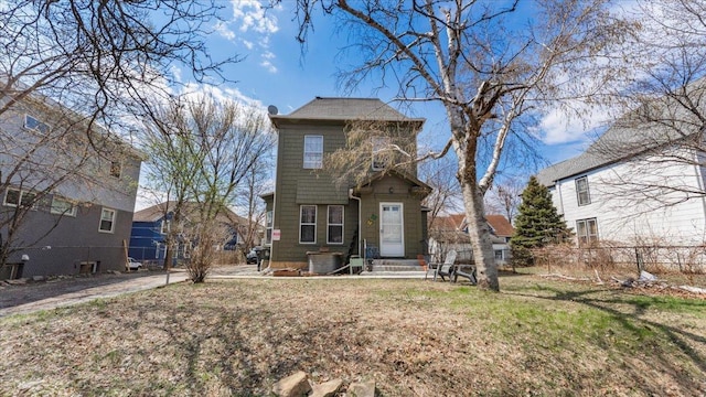 traditional-style home featuring a front yard, fence, central AC unit, and entry steps