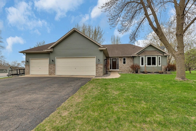 single story home with brick siding, a garage, driveway, and a front yard