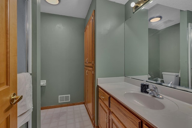 bathroom with tile patterned floors, vanity, toilet, and visible vents