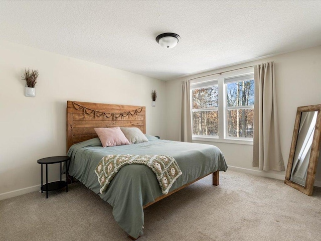 bedroom featuring carpet flooring, a textured ceiling, and baseboards