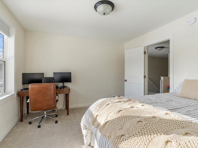 bedroom with baseboards and light carpet