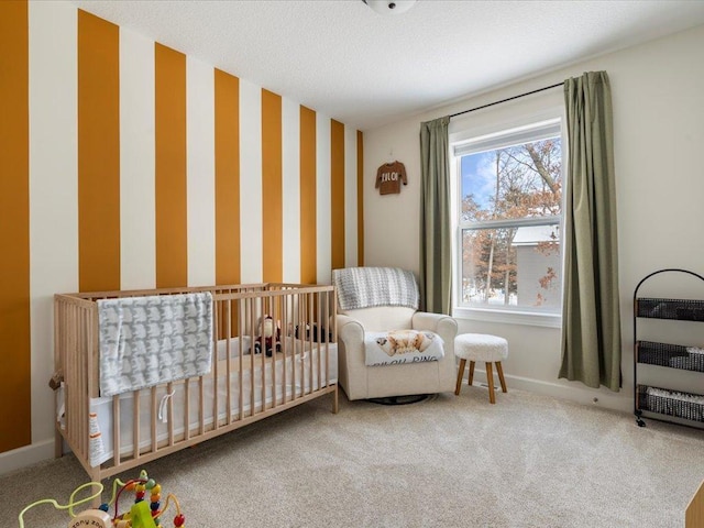 carpeted bedroom featuring a nursery area, wallpapered walls, and baseboards