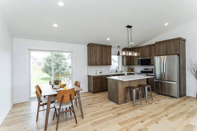 1812 Brandt Dr NE, Byron, MN 55920 - kitchen featuring stainless steel appliances, a center island, dark brown cabinets, decorative backsplash, and light countertops