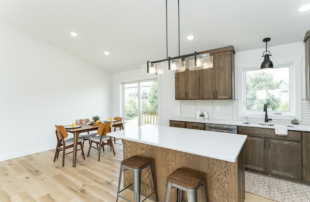 1812 Brandt Dr NE, Byron, MN 55920 - kitchen featuring a kitchen island, light wood-style flooring, backsplash, recessed lighting, and light countertops