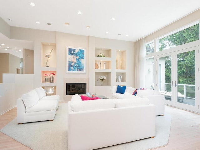 2673 Cedar Grn, Minnetonka, MN 55305 - living room featuring built in shelves, light wood-type flooring, french doors, a glass covered fireplace, and recessed lighting