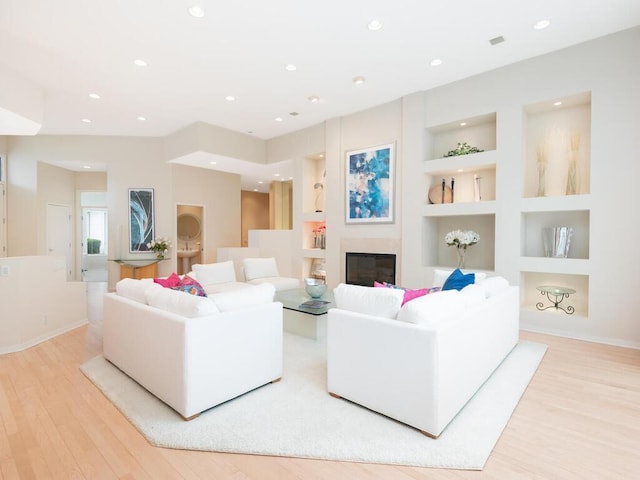 2673 Cedar Grn, Minnetonka, MN 55305 - living room featuring built in shelves, wood finished floors, recessed lighting, a glass covered fireplace, and baseboards