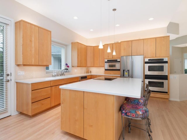 2673 Cedar Grn, Minnetonka, MN 55305 - kitchen featuring appliances with stainless steel finishes, light wood-type flooring, a sink, a kitchen island, and a breakfast bar