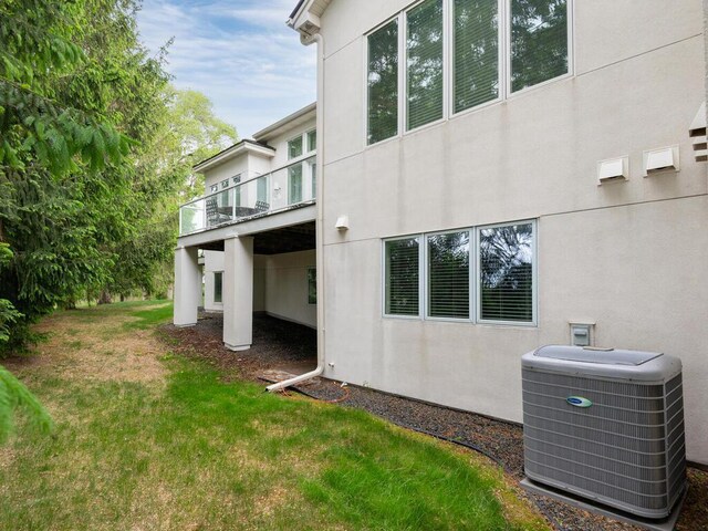 2673 Cedar Grn, Minnetonka, MN 55305 - view of side of home featuring cooling unit, a balcony, stucco siding, and a yard