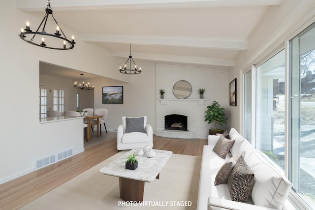 living area featuring an inviting chandelier, wood finished floors, and visible vents