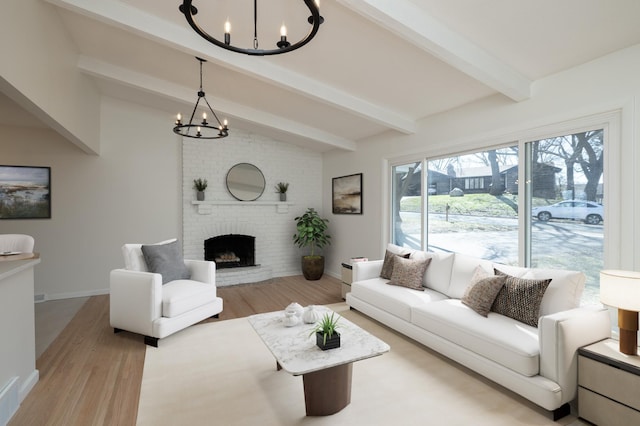 living area with an inviting chandelier, lofted ceiling with beams, wood finished floors, and a fireplace